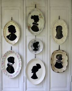 plates with silhouettes on them hang from the wall