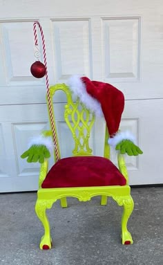 a green chair with red velvet seat and santa's hat on it, sitting in front of a garage door