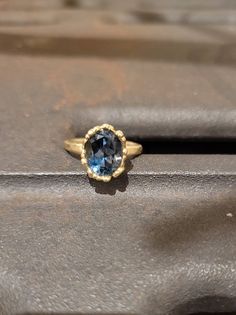 This is a 14 karat gold ring with an oval blue topaz london gem. Its a beatifull  delicate ring that can be used as an anniversary or engagement ring, or a gift for yourself, or for a loved one. ITEM DETAILSMaterial: The ring is made of 14 karat gold and set with an oval blue topaz london. Sizes: you can order this ring in sizes 4-9. All my jewelry are sent in a black carton monogramed gift box.Free shippingPlease note that you may be charged taxes by your country's customs, please check this be Luxury 14k Gold Oval Topaz Ring, Oval Yellow Gold Topaz Ring With Center Stone, Timeless Gold Oval Topaz Ring, Timeless Oval Gold Topaz Ring, Gold Oval Blue Topaz Birthstone Ring, Oval Sapphire Ring With Halo Setting In 14k Gold, Modern Oval Blue Topaz Ring, Blue Oval Topaz Ring In 14k Gold, Oval Blue Topaz Ring In 14k Gold