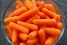 a bowl filled with carrots sitting on top of a table