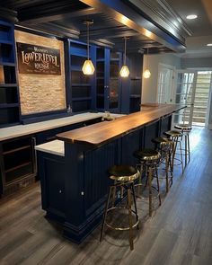 an empty bar with stools in the middle and lights hanging from the ceiling above it