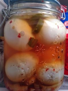 a jar filled with pickles sitting on top of a counter next to other items