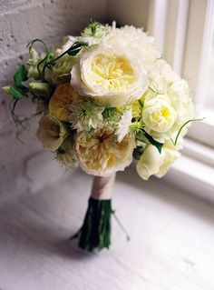 a bridal bouquet sitting on top of a window sill