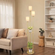 a living room filled with furniture and a tall planter on top of a hard wood floor