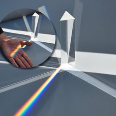 a person's hand reaching for a rainbow in the middle of a circular object