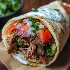 a burrito filled with meat, vegetables and sour cream