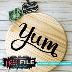 a round wooden sign with the word yum written in cursive font on it