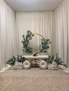 a room with white drapes and two round wreaths on top of the floor