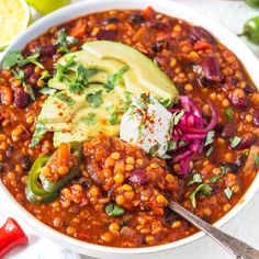 a white bowl filled with beans and avocado garnished with cilantro