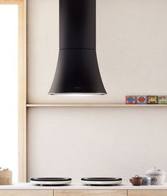 a modern kitchen with black hood over the stove