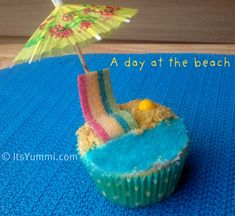 there is a cupcake with an umbrella in it on the blue tablecloths