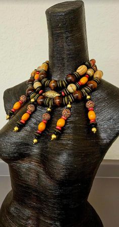 This piece is showy and dramatic, yet very lightweight and comfortable to wear. A triple strand statement necklace supports five beaded wire dangles, which can simply be straighted should they ever get bent. The statement necklace features a golden repousse bicone bead, wood rondelles, oversized big round chocolate beads, blonde wood barrels, conch shell, coral rondelles, vintage Chinese brass coins, Moroccan resin, picture jasper, etched brown resin with a dragon motif, black plastic spacers an Dragon Motif, Get Bent, Blonde Wood, Statement Bib Necklace, Chest Piece, Metal Ball, Conch Shell, Picture Jasper, Simply Be