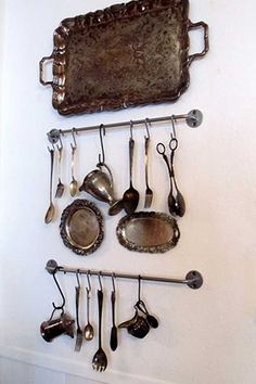 there is a wall mounted rack with spoons and utensils hanging on it