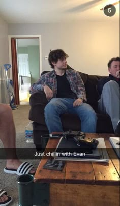 two men sitting on a couch in a living room with the caption just chillin with evan