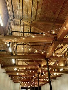 the ceiling is covered with wooden planks and string lights hanging from it's sides