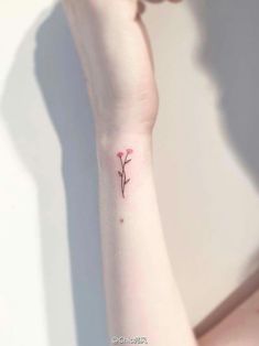 a small flower tattoo on the wrist