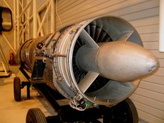 an airplane engine sitting on top of a cart next to a garage door and stairs