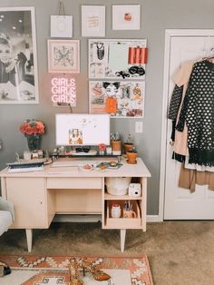 a desk with a computer on top of it in front of pictures and other items