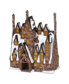 a toy house with snow on the roof and chimneys, in front of a white background