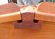 a close up of a wooden bench with two pieces of wood attached to the seat