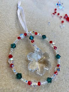 an ornament made out of glass beads with a flower on it and a beaded cord