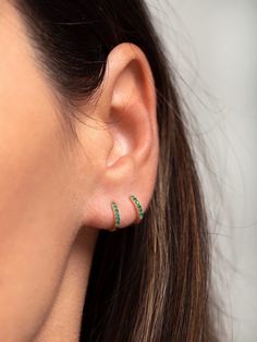 "An all-time bestseller with emerald green zirconia stones. Elegant and classic, these tiny huggie hoops prong-set with brilliant zirconia gemstones are a beautifully dainty addition to your everyday lineup. Subtle, versatile and perfect to mix and match with other earrings. ∙ Sold individually (1 hoop) or by pair (2 hoops). * D E T A I L S * ∙ Material: .925 Sterling Silver or 18K Gold Plated over .925 Sterling Silver ∙ Stone: Green Zirconia ∙ Dimensions: Hoop Diameter: 11mm // Width: 1.5mm ∙ H Cheap Green Hoop Earrings, May Birthstone Round Hoop Earrings For Pierced Ears, May Birthstone Round Hoop Earrings, Elegant Green Hoop Huggie Earrings, Elegant Green Huggie Hoop Earrings, Green Huggie Earrings For May Birthstone, Dainty Hoop Earrings With May Birthstone, Dainty May Birthstone Hoop Earrings, Dainty May Birthstone Hoop Jewelry