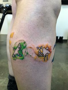 a man's leg with tattoos on it and two cats painted on the side