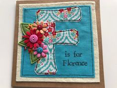 a card with the letter f on it and flowers in front of it that says, is for florence