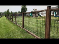 the fence is made of metal wire and has a green slide in the back yard