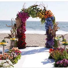 an outdoor wedding setup with flowers on the beach