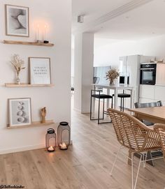 a dining room table with chairs and pictures on the wall above it, along with candles