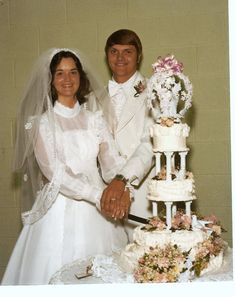 a bride and groom are cutting their wedding cake