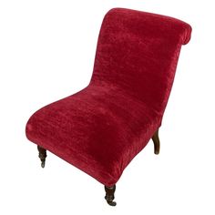 an upholstered red chair with wooden legs and foot rests on a white background