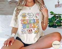 a beautiful woman sitting on top of a bed wearing a t - shirt that says pediatric nurse