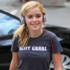 a girl with headphones walking down the street