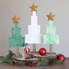 a christmas tree made out of wooden blocks and other decorations on top of a table