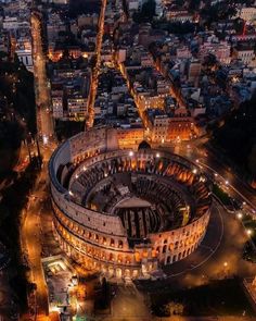 an aerial view of the roman colossion at night, with city lights in the background