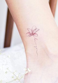 a woman's foot with a flower tattoo on the side of her leg,