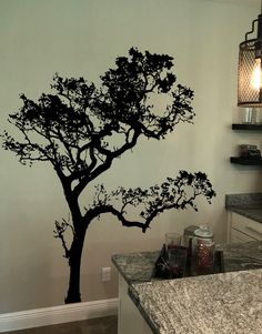 a wall with a tree painted on it and two lights hanging from the ceiling above