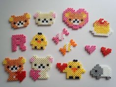 several pieces of perler bead art on a white surface, including an animal and heart