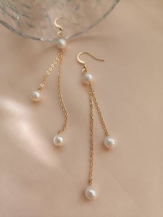 These dainty long chain pearl earrings are made of white freshwater pearls and 14k gold plated chains and ear hooks. It looks elegant on your different daily outfits. The earrings are perfect for parties and weddings. There are two options gold and silver plated for you to choose from. The pearl size is about 6mm and the total earring length is 7cm approx. The item is packaged in a single jewellery pouch. Caring for your jewellery will keep it in brilliant condition. Avoid getting the jewellery Diy Earrings Dangle, Pearl Earrings Long, Dangle Pearl Earrings, Diy Earrings Easy, Bridesmaid Pearl Earrings, Homemade Earrings, Bridesmaids Earrings, Diy Jewelry Unique, Handmade Jewelry Tutorials