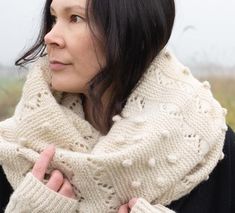 a woman wearing a white knitted scarf