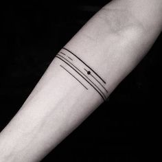 a black and white photo of a person's arm with a line tattoo on it