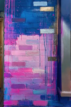 a blue and pink painted brick wall next to a doorway