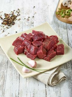 raw meat on a plate with garlic and pepper