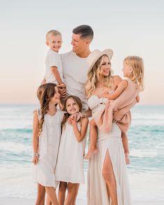 a family standing on the beach in front of the ocean