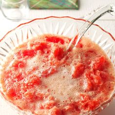 a close up of a bowl of food on a table with a utensil in it