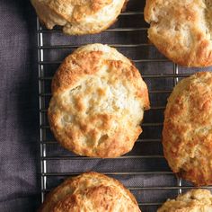 four biscuits cooling on a wire rack, with one baked and the other uncooked