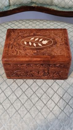 a wooden box sitting on top of a bed