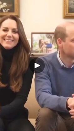 a man and woman sitting on top of a couch next to each other in a living room